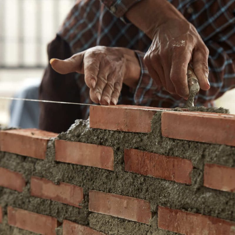 primer-plano-de-la-mano-del-hombre-en-la-pared-de-ladrillo (1) (1) (1)