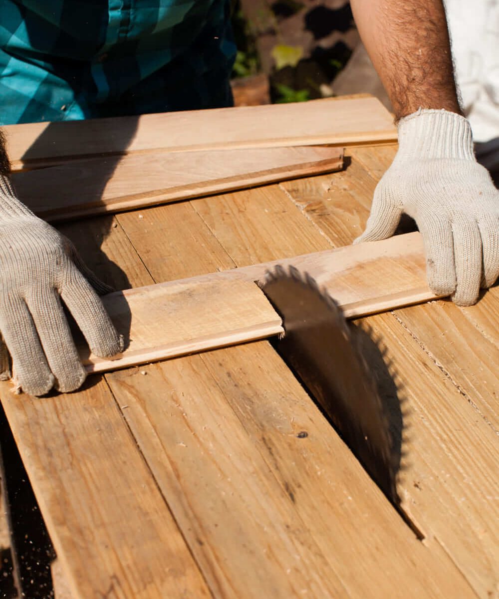 trabajador-de-la-madera-cortando-tablones-de-madera-se-centran-en-la-sierra (1) (1)